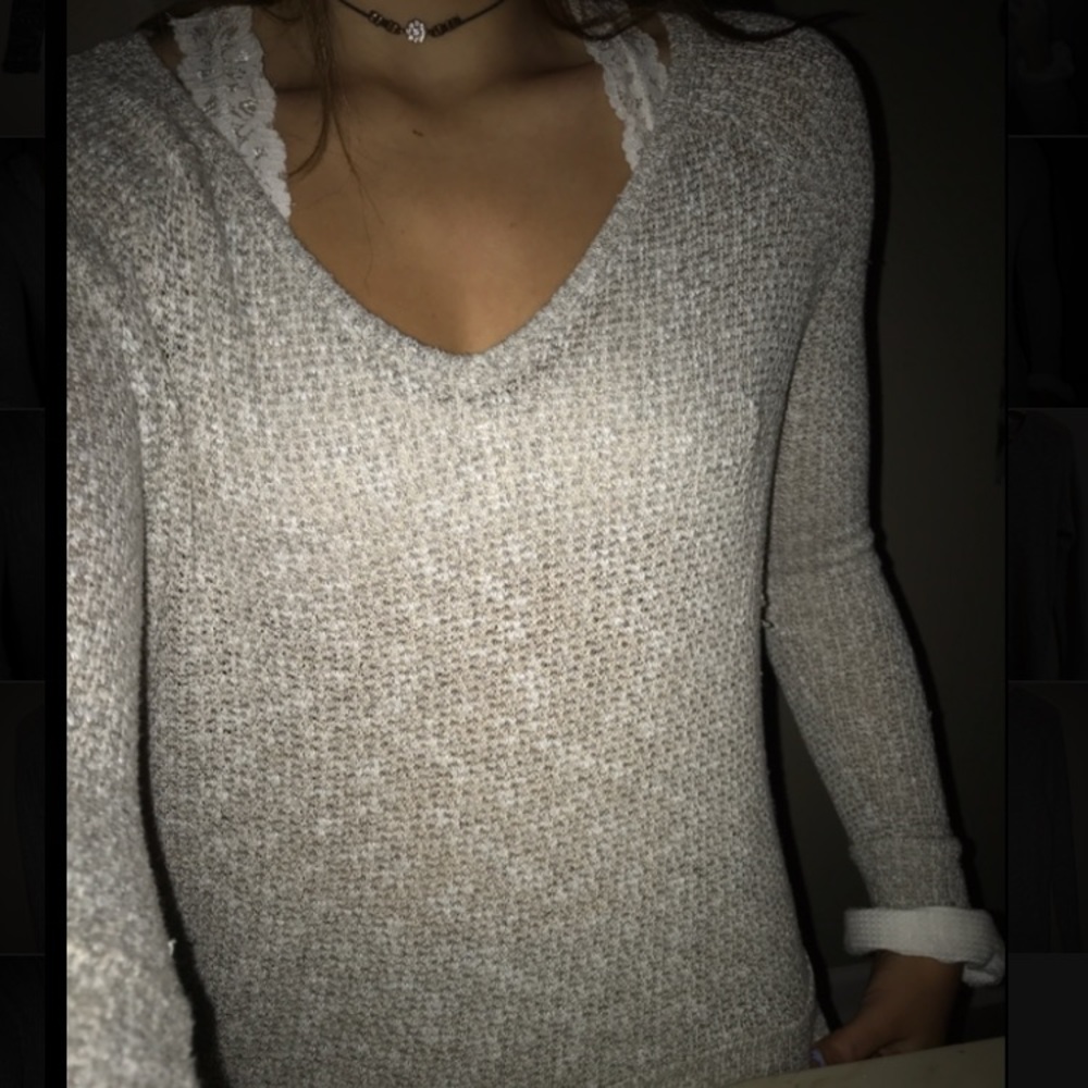 A gray and white speckled v-neck sweater.